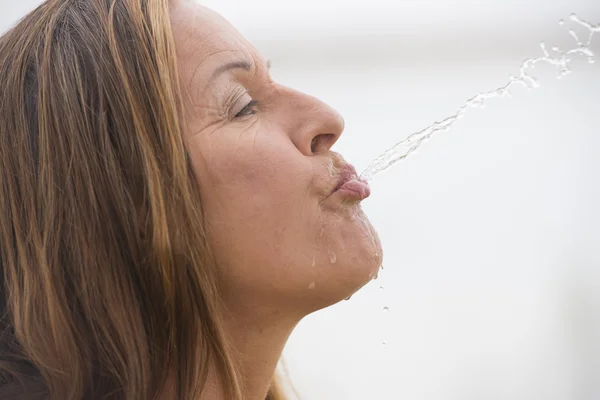 Woman spewing water for fun refreshment — Stock Photo, Image
