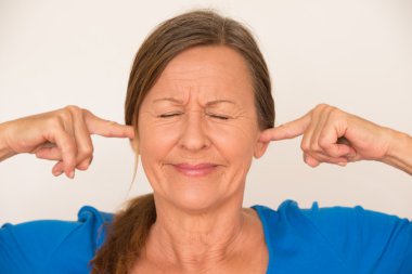 Stressed woman covering ears