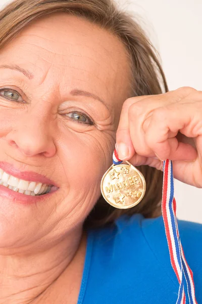 Happy smiling woman presenting gold medal — Stock fotografie