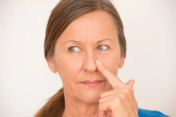 Mujer seria inteligente dedo en la nariz — Foto de Stock