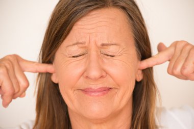 Stressed Woman blocking ears with finger