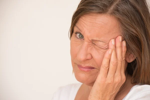 Worried angry upset woman one eye closed — Stockfoto