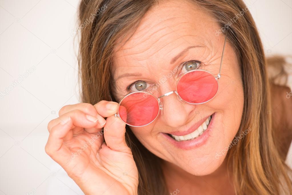 Happy relaxed mature woman red glasses