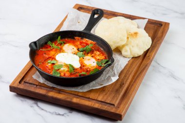 Shakshuka - çırpılmış yumurta, sebzeli, fasulyeli ve domatesli yağda kızarmış ekmek.
