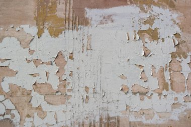 Duvardaki çatlak alçının üzerinde pullar ve boya sızıntıları var.