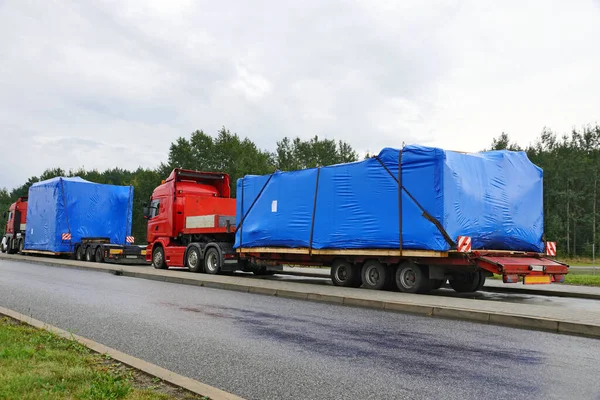 A trucks with a special semi-trailers for transporting oversized loads. Oversize load or exceptional convoy.