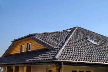 Interestingly solved roof surface. Roof made of metal roof tiles.  clipart