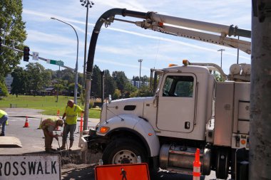 İşçiler özel bir araçtan yüksek basınçlı hava ve su kullanıyorlar. Şehirde tadilat yapılıyor.. 