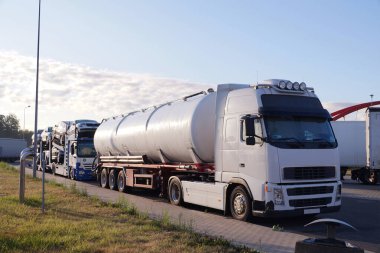 Çeşitli mallar taşıyan kamyonlar. Fotoğrafta yolcu vagonu taşımak için bir tanker ve bir kamyon görünüyor. Yol taşımacılığı. 