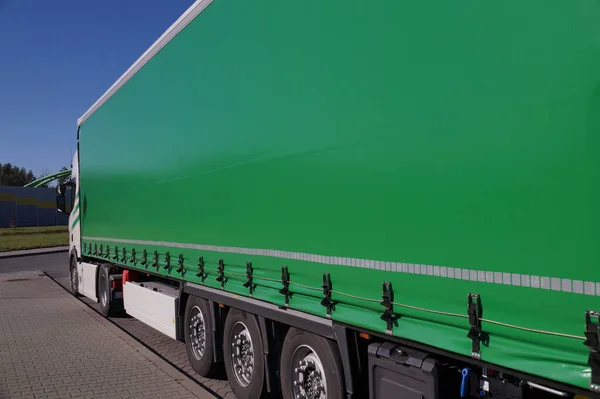 トラック輸送だ トラックの半トレーラーを覆う緑のターパリンの眺め — ストック写真