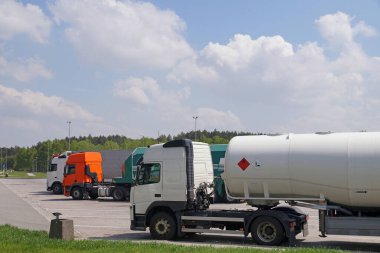 Hareket halindeyken çeşitli ağır yük araçları. Kamyonlar için park. 