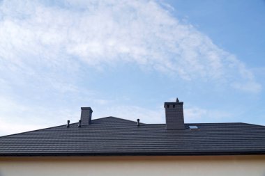 Yeni inşa edilmiş bir ev. Çatının metal çatı kiremitlerinden yapılmış bir parçası.. 