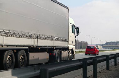 Otoyol. İki farklı yol kullanıcısı: büyük bir kamyon ve küçük bir yolcu arabası.