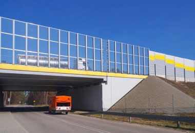Otoyol ses emici bariyerlerle çevrili. Otoyolun altında, yerel yol için bir viyadük var..