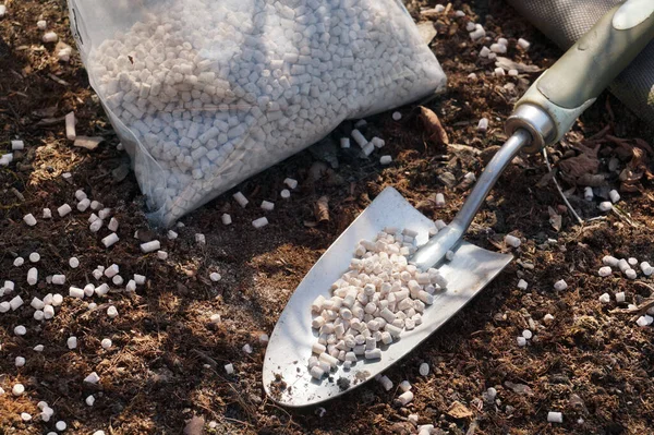 Foil bag with fertilizer. Gardening spatula. Spring care works.