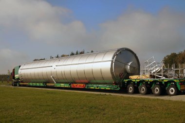 Uzun bir araç. Olağanüstü bir konvoy. Karavanda alışılmadık derecede uzun bir yük taşıyan bir kamyon..