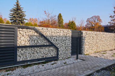 Gabiondan yapılmış duvara otomatik giriş kapısı ve kale entegre edildi. Gabiyonlardan yapılmış bir çit.. 