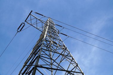 Elektrik transferi. Mavi gökyüzüne karşı yüksek voltajlı elektrik hattı.