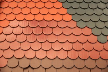 Roofing. Roof tiles of the same shape but differing in color and surface finish.