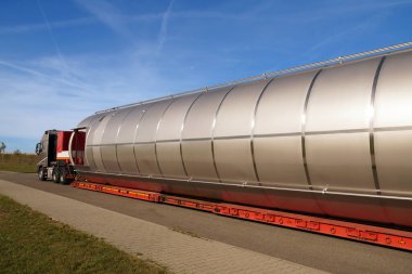 Uzun bir araç, düşük yükleme karavanı olan bir kamyon. Aşırı yükleme ya da istisnai konvoy. Ağır yük taşımak için özel yarı karavanı olan bir kamyon. Çok uzun bir araç. 