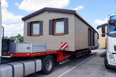 A very long and wide vehicle. Oversized cargo or exceptional convoy. A truck with a special semi-trailer for the transport of oversized cargo - transport of finished houses.