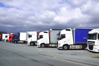 Dinlenme yeri. Otobanın yanındaki otoparkta çeşitli kamyonlar var..