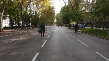 Passeo del Prado, Madrid, İspanya 'da yüz maskesi takan yayalar yürüyor
