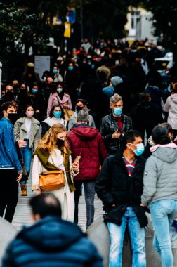 Madrid, İspanya - 15 Kasım 2020 Madrid, İspanya 'da kalabalık yaya caddesi. Covid-19 salgını sırasında insanlar zorunlu yüz maskesi takıyor.