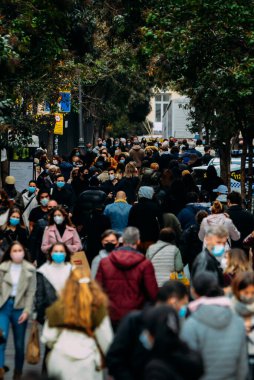 Madrid, İspanya - 15 Kasım 2020 Madrid, İspanya 'da kalabalık yaya caddesi. Covid-19 salgını sırasında insanlar zorunlu yüz maskesi takıyor.