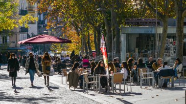 Madrid / İspanya - 21 Kasım 2020: İspanya 'nın orta Madrid kentindeki popüler Malasana mahallesindeki teras kafeteryasında insanlar dinleniyor. Bazıları yüz maskesi takar