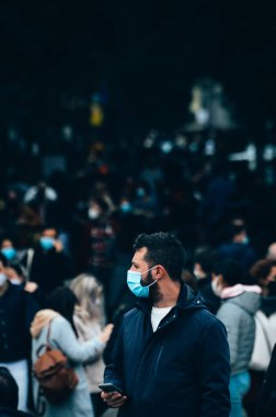 Madrid, İspanya - 21 Kasım 2020 Madrid, İspanya 'da kalabalık yaya caddesi. Covid-19 salgını sırasında insanlar zorunlu yüz maskesi takıyor. 300mm 'de yakalandı. Bokeh seçici odak