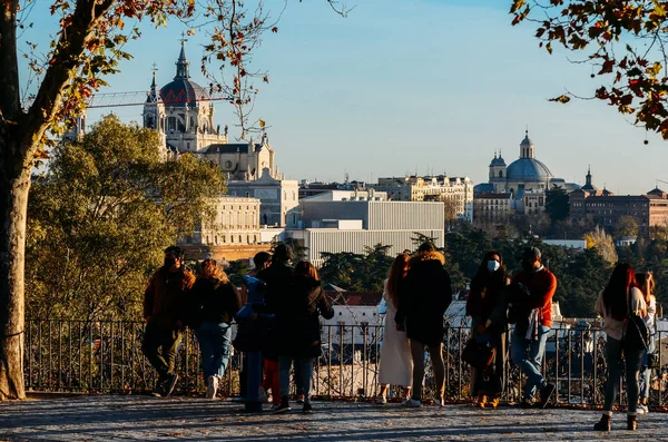 Mensen bewonderen het uitzicht op het Koninklijk Paleis en de Almudena Kerk in Parque del Oeste Park, Madrid, Spanje — Stockfoto