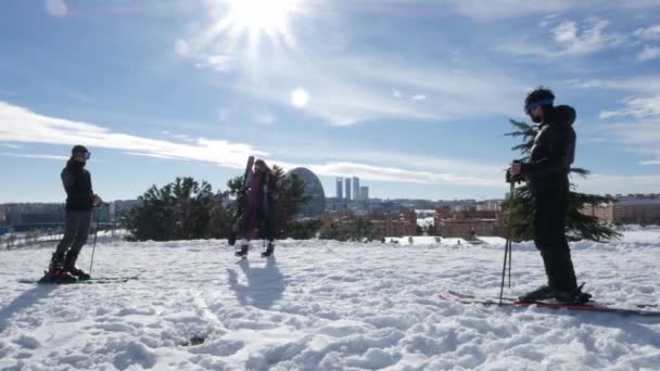 Eine Gruppe von Skifahrern entspannt sich, während sie die Wolkenkratzer des Bankenviertels in Madrid nach den heftigen Schneefällen in Madrid, Spanien, überblickt — Stockvideo
