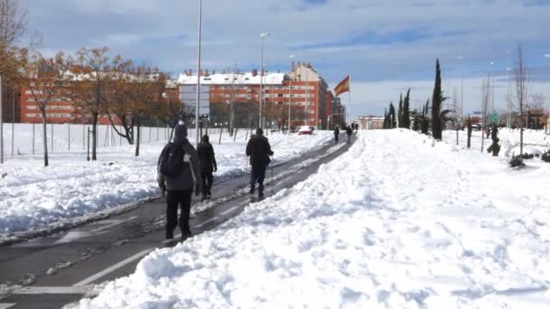 Mensen lopen op straat in de buurt Las Tablas in het noorden van Marid, Spanje na een zware sneeuwstorm — Stockvideo