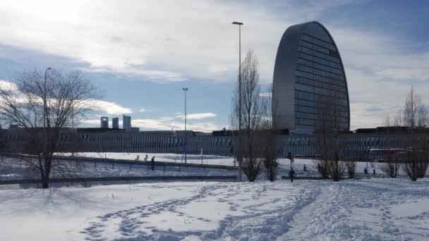 Menschen gehen draußen im Schnee in der Nähe der BBVA-Zentrale in Las Tablas, Madrid, Spanien — Stockvideo