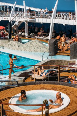 Denizde - 31 Ekim 2025: Güneşli bir günde MSC Divina yolcu gemisinde kalabalık bir yüzme havuzu alanı