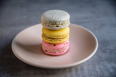 Fransız badem kurabiyeleri bir tabağın üzerinde piramide istiflenmiş..