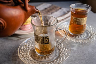 Türk bardaklarında altın desenli Fransız çörekleri ve çayı.