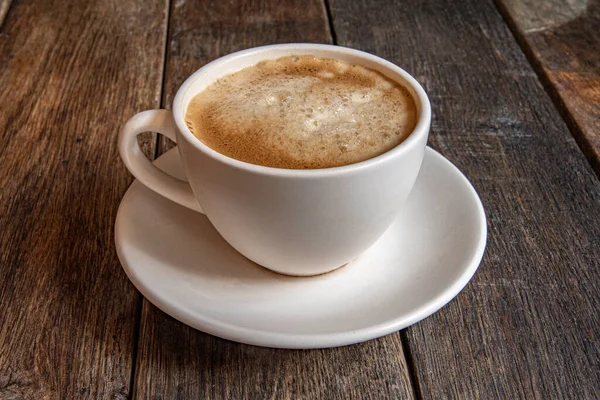 Eine Tasse Kaffee Auf Einer Untertasse Auf Einem Hölzernen Hintergrund — Stockfoto