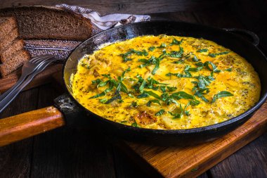 Fırında pişirilmiş dökme demir tavada patatesli kırsal omlet..