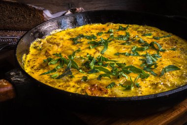 Fırında pişirilmiş dökme demir tavada patatesli kırsal omlet..