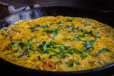 Fırında pişirilmiş dökme demir tavada patatesli kırsal omlet..