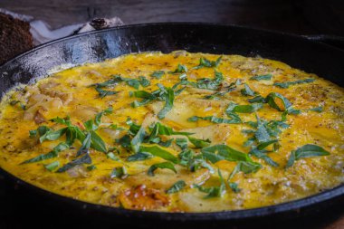 Fırında pişirilmiş dökme demir tavada patatesli kırsal omlet..