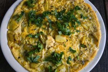 Tahta masadaki patatesli gerçek bir kırsal omlet..