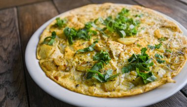 Tahta masadaki patatesli gerçek bir kırsal omlet..