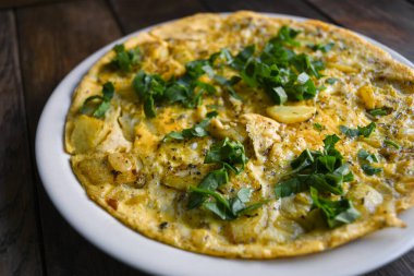 Tahta masadaki patatesli gerçek bir kırsal omlet..