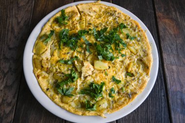 Tahta masadaki patatesli gerçek bir kırsal omlet..