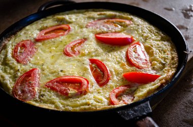 Dökme demir tavada patates ve domatesli Rustik omlet..