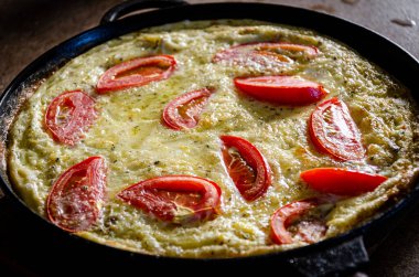 Dökme demir tavada patates ve domatesli Rustik omlet..