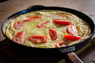 Dökme demir tavada patates ve domatesli Rustik omlet..